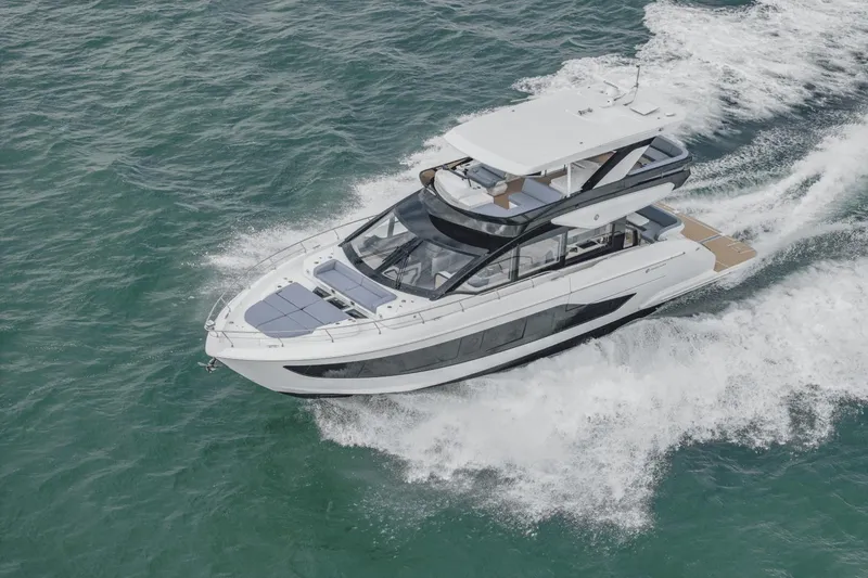 Slide: The Image of 2025 Cruisers Yachts 57 Fly cruising on open water, showcasing sleek design and luxury features. - 2