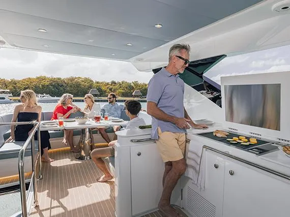 Slide: The Image of People enjoying a meal on a 2025 Cruisers Yachts 57 Fly. - 24