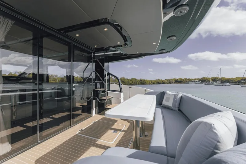 Slide: The Image of Luxurious 2025 Cruisers Yachts 57 Fly deck with elegant seating and scenic water view. - 28