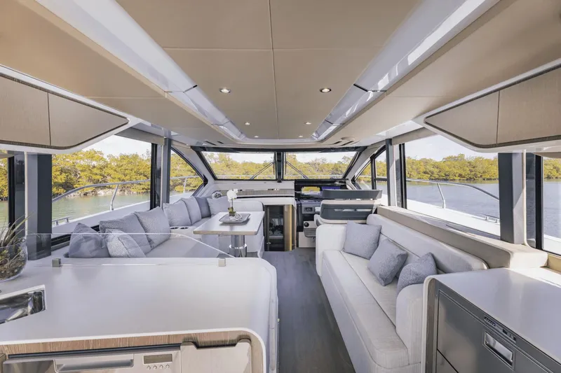 Slide: The Image of Luxurious interior of 2025 Cruisers Yachts 57 Fly, featuring modern seating and panoramic windows. - 29