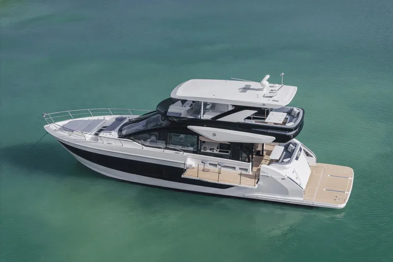 Slide: The Image of 2025 Cruisers Yachts 57 Fly luxury yacht on clear turquoise water. - 8