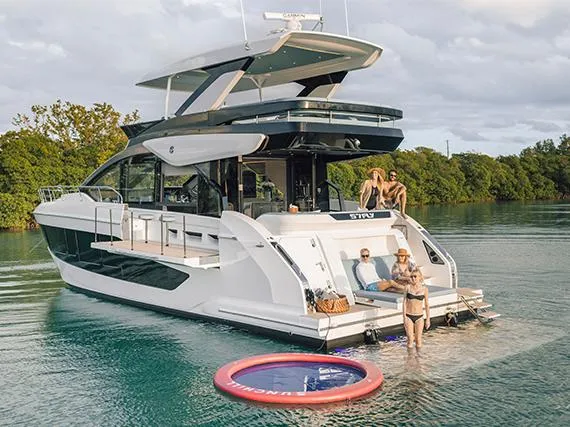 Slide: The Image of Luxury Cruisers Yachts 57 Fly 2026 on calm water with relaxed crew. - 9