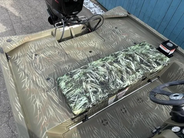 Slide: The Image of 2024 Tracker Grizzly 1860 CC boat interior with camo seating and steering wheel. - 17