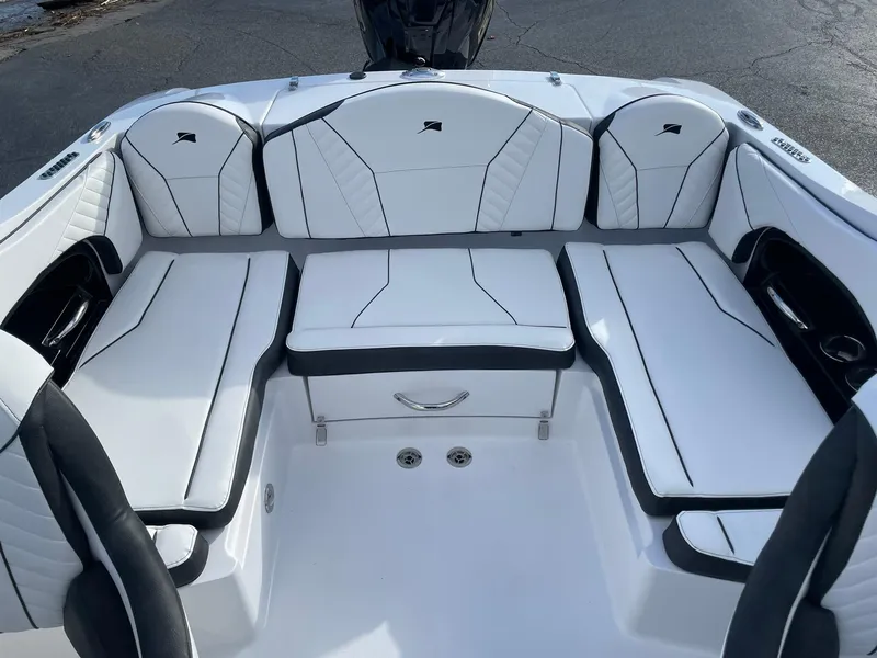 Slide: The Image of Interior seating of 2025 Stingray 23 OSX boat, featuring white and black upholstery. - 11