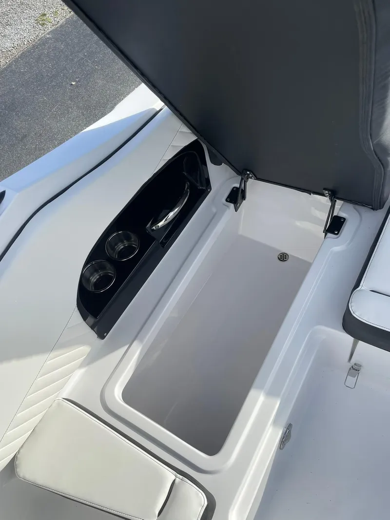 Slide: The Image of 2025 Stingray 23 OSX boat storage compartment with open lid, showcasing sleek design and functionality. - 15
