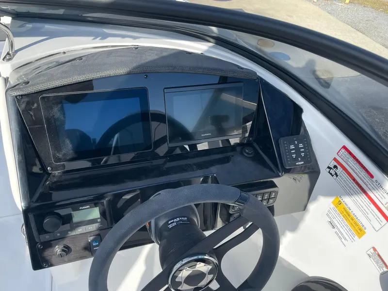 Slide: The Image of Dashboard of 2025 Stingray 23 OSX boat with dual screens and steering wheel. - 19