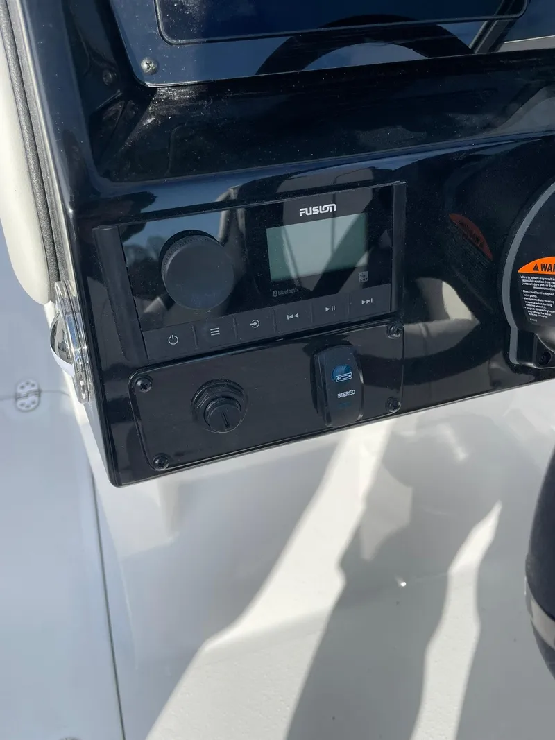 Slide: The Image of Control panel of 2025 Stingray 23 OSX boat featuring Fusion audio system. - 23