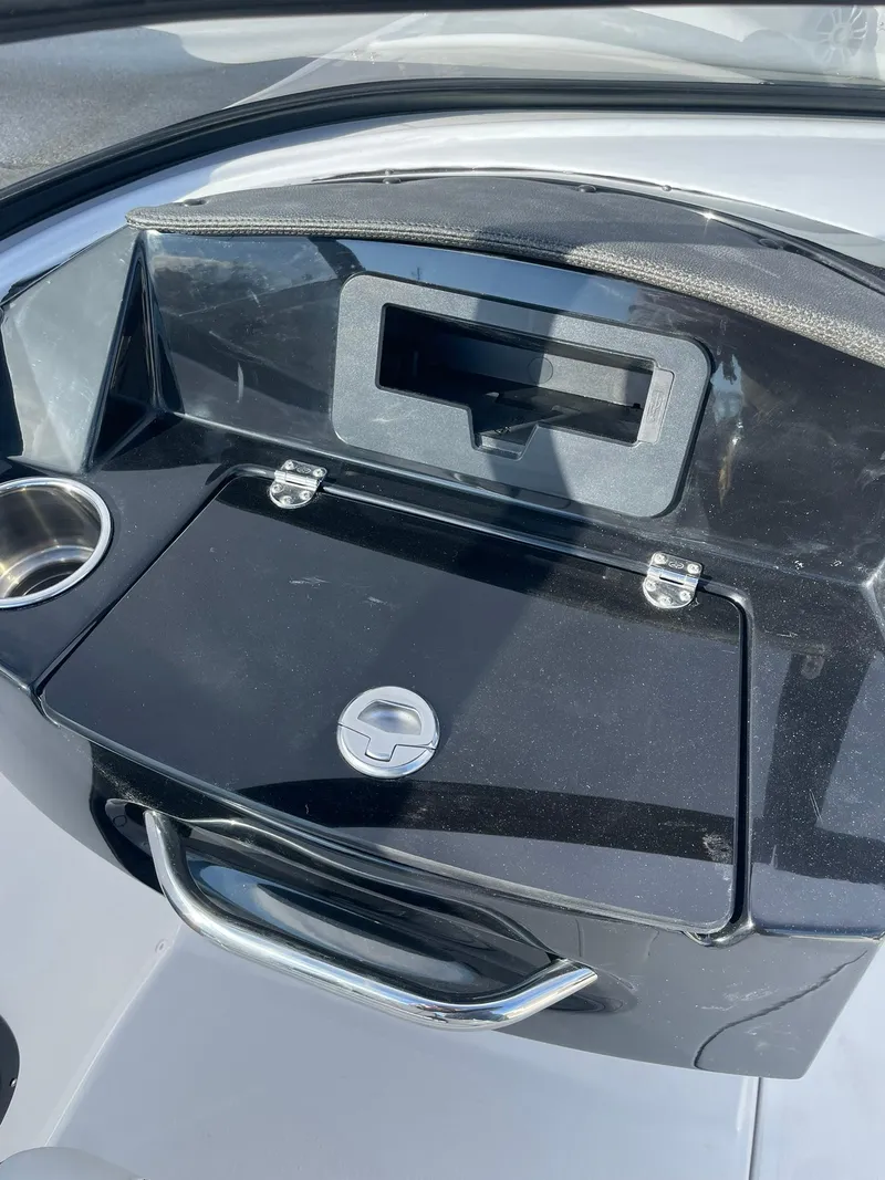 Slide: The Image of 2025 Stingray 23 OSX dashboard with storage compartment and cup holder. - 24