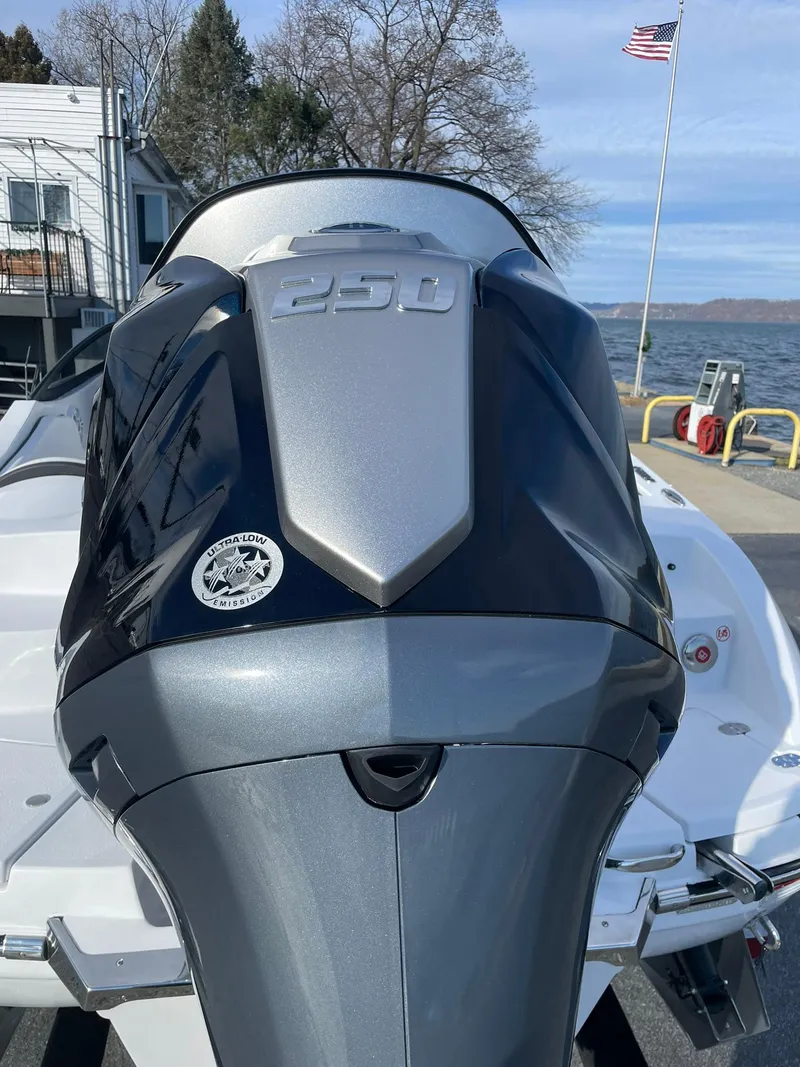 Slide: The Image of 2025 Stingray 23 OSX boat with powerful engine, docked by a lake with American flag. - 4