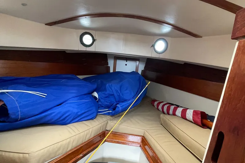 Slide: The Image of Interior cabin of 1978 Legnos Mystic 30 sailboat with cushions and blue covers. - 6