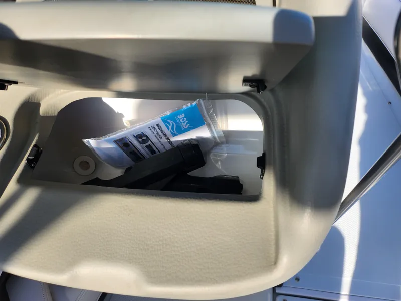 Slide: The Image of Open storage compartment in 2012 Crownline 21 SS boat with items inside. - 14
