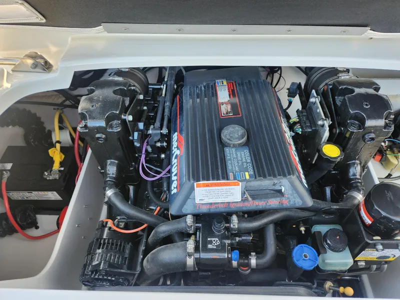 Slide: The Image of 2012 Crownline 21 SS boat engine compartment with visible components and wiring. - 21