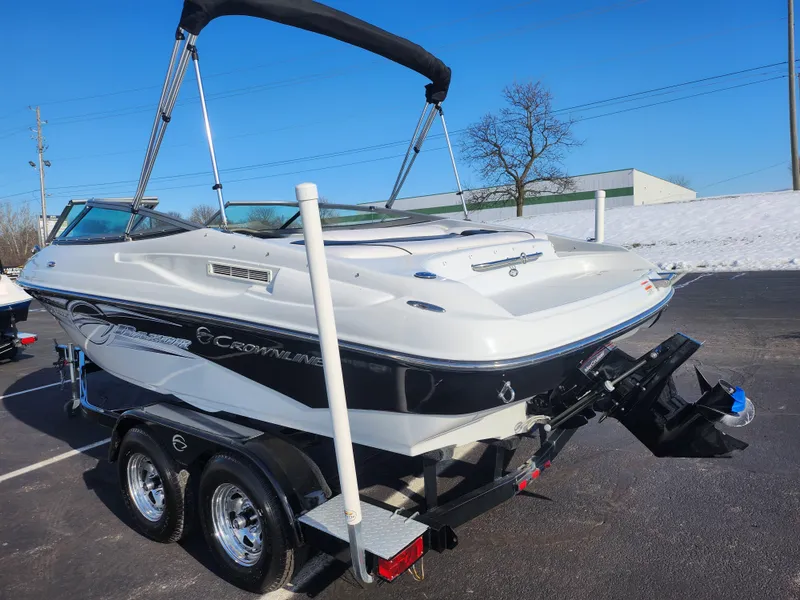 Slide: The Image of 2012 Crownline 21 SS boat on trailer, parked outdoors on a sunny day. - 3