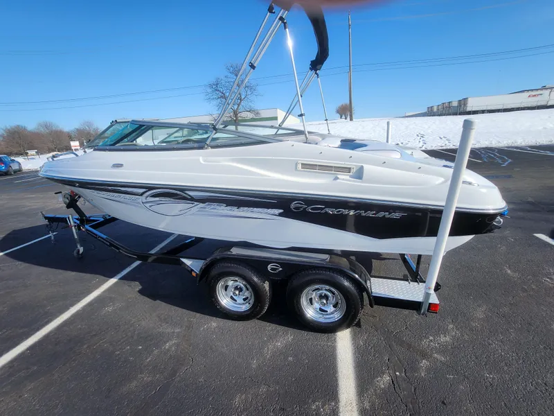 Slide: The Image of 2012 Crownline 21 SS boat on trailer in parking lot, clear sky background. - 4