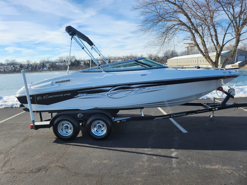 Slide: The Image of 2012 Crownline 21 SS boat on trailer by lakeside, clear sky background. - 9