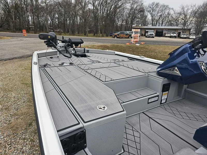 Slide: The Image of 2025 Avid 18 Vertex Crappie boat with sleek deck design, parked outdoors. - 2