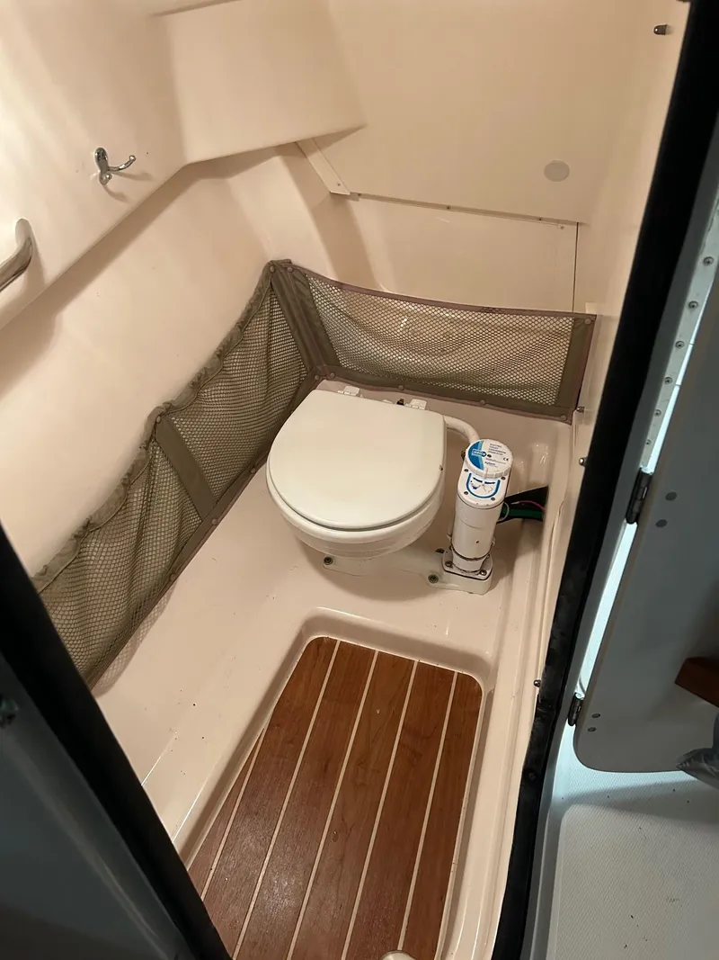 Slide: The Image of 2014 Grady-White Freedom 255 boat bathroom with wooden flooring and compact design. - 6