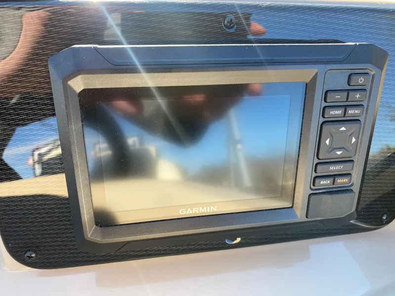 Slide: The Image of Garmin display on 2025 SunCatcher Select 322RC boat dashboard, reflecting sunlight. - 15