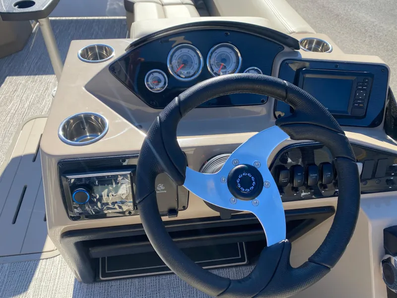 Slide: The Image of 2025 SunCatcher Select 322RC boat dashboard with steering wheel and gauges. - 17