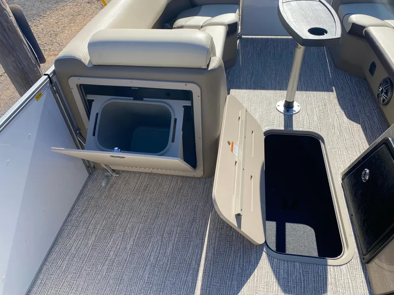 Slide: The Image of 2025 SunCatcher Select 322RC interior with storage compartments and seating on a pontoon boat. - 18