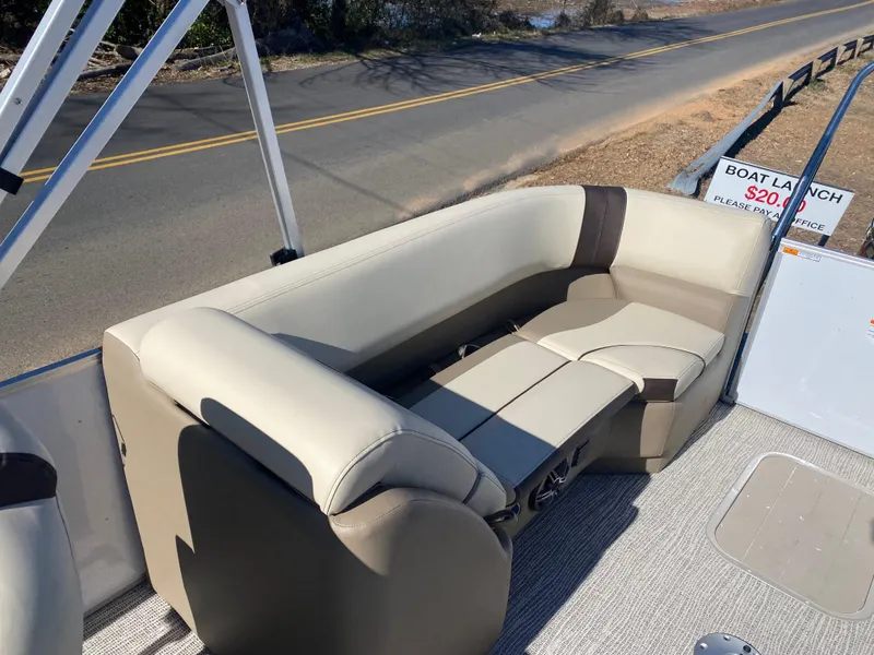 Slide: The Image of 2025 SunCatcher Select 322RC boat interior with beige seating, near a road. - 19