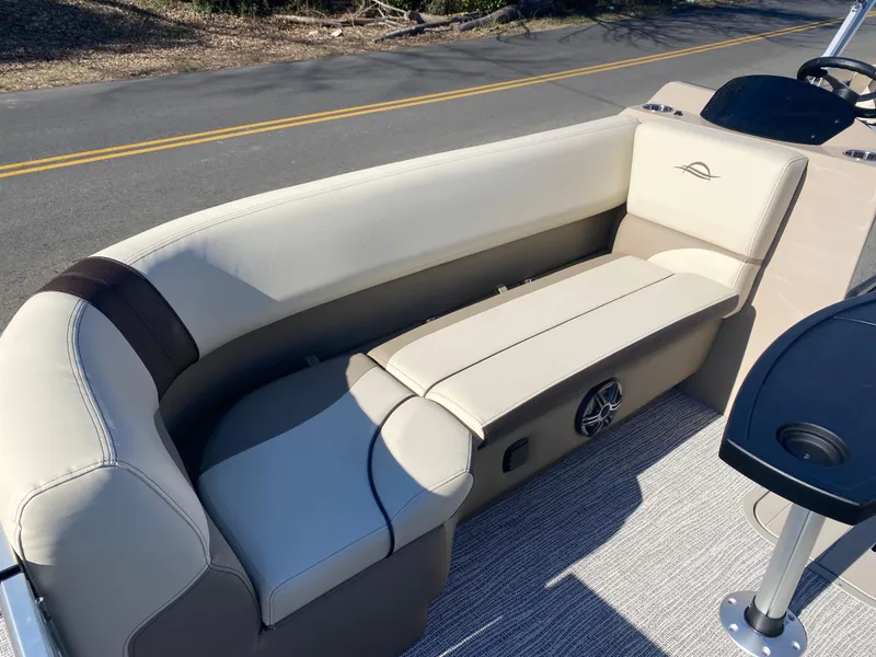 Slide: The Image of 2025 SunCatcher Select 322RC boat interior with beige seating and speaker system. - 21
