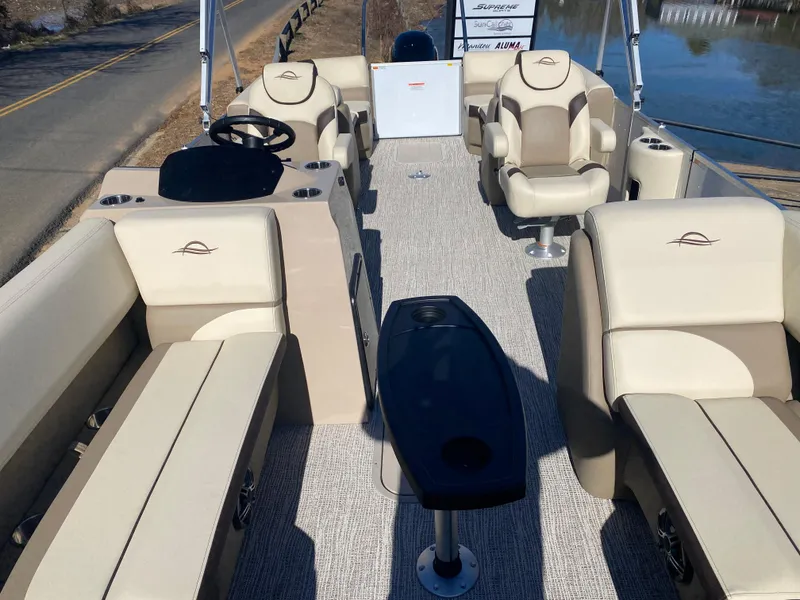Slide: The Image of 2025 SunCatcher Select 322RC pontoon boat interior with beige seating and steering console. - 22