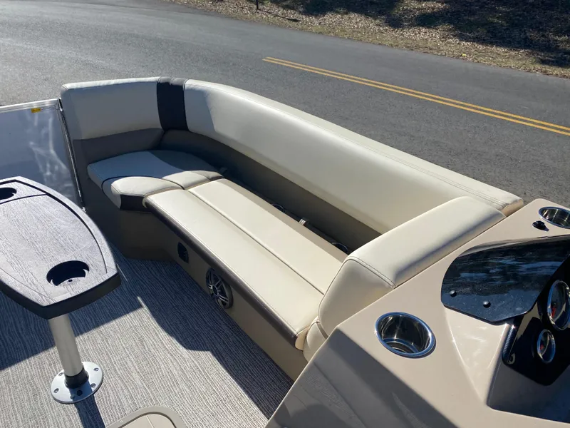 Slide: The Image of Luxurious seating on 2025 SunCatcher Select 322RC boat, featuring beige upholstery and cup holders. - 23