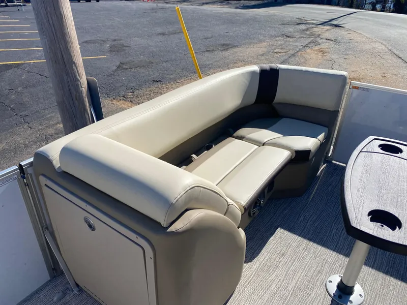 Slide: The Image of 2025 SunCatcher Select 322RC boat interior with beige seating and table. - 25