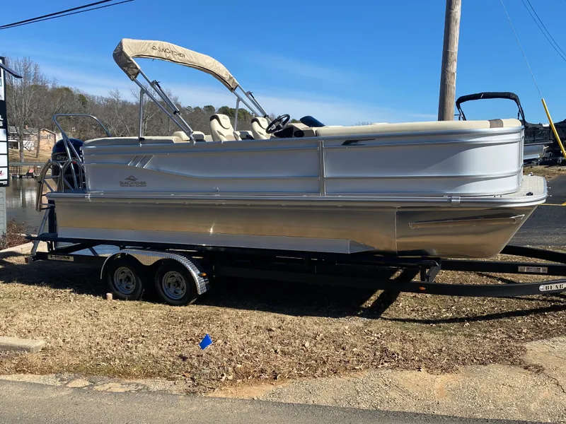 Slide: The Image of 2025 SunCatcher Select 322RC pontoon boat on trailer, parked outdoors. - 4