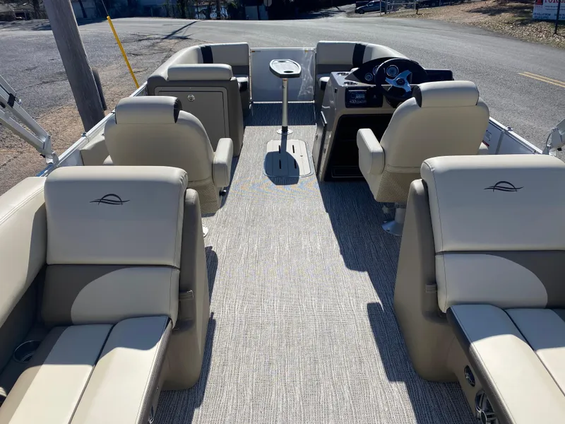 Slide: The Image of 2025 SunCatcher Select 322RC pontoon boat interior with beige seating and steering console. - 7
