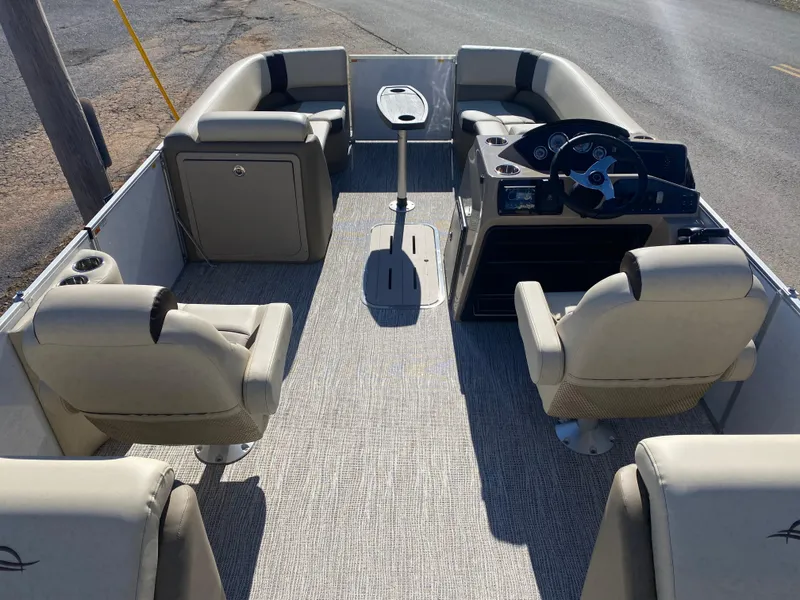 Slide: The Image of 2025 SunCatcher Select 322RC pontoon boat interior with beige seating and steering console. - 8