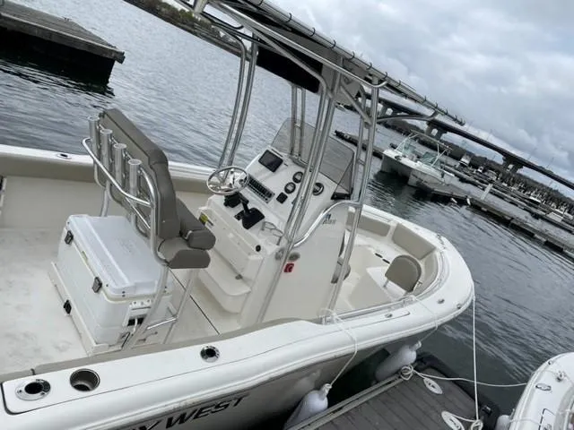 Slide: The Image of 2022 Key West 219 FS boat docked at marina, featuring center console and seating. - 2
