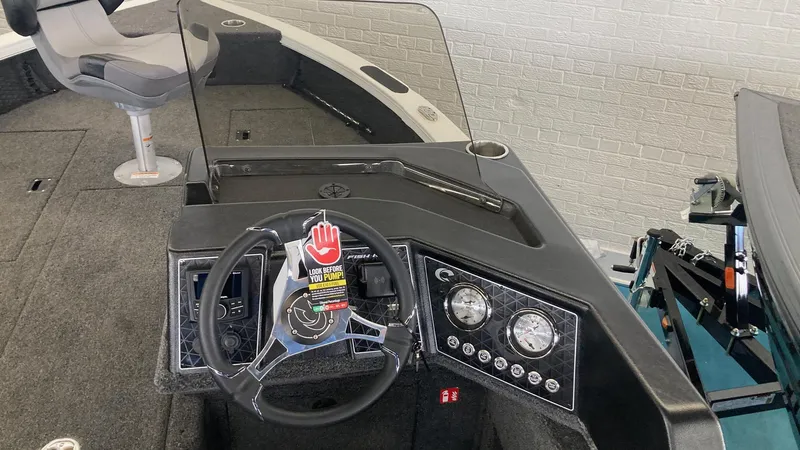 Slide: The Image of 2025 Crestliner 1750 Fish Hawk boat interior with steering wheel and dashboard controls. - 5