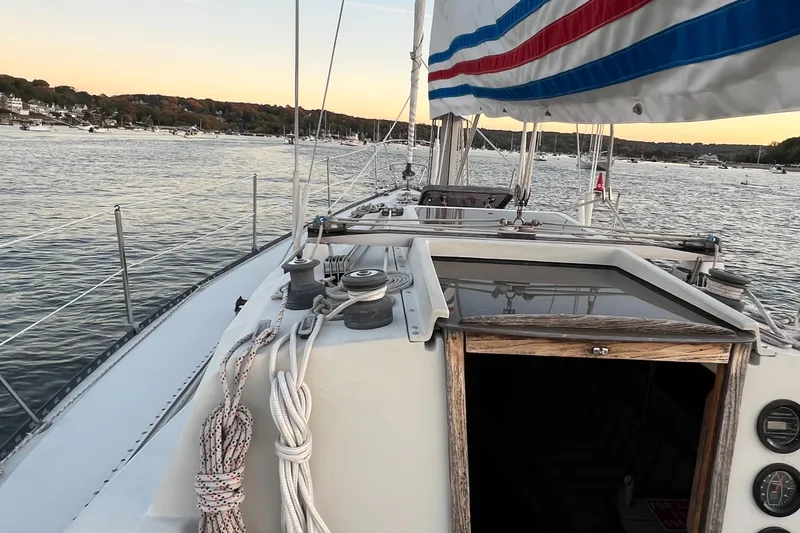 Slide: The Image of 1983 C&C 35 MKIII sailboat on calm water, view from deck, sunset in background. - 33