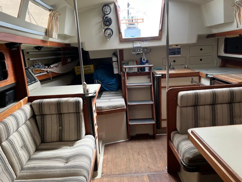 Slide: The Image of Interior of 1983 C&C 35 MKIII sailboat with striped seating and wooden accents. - 36