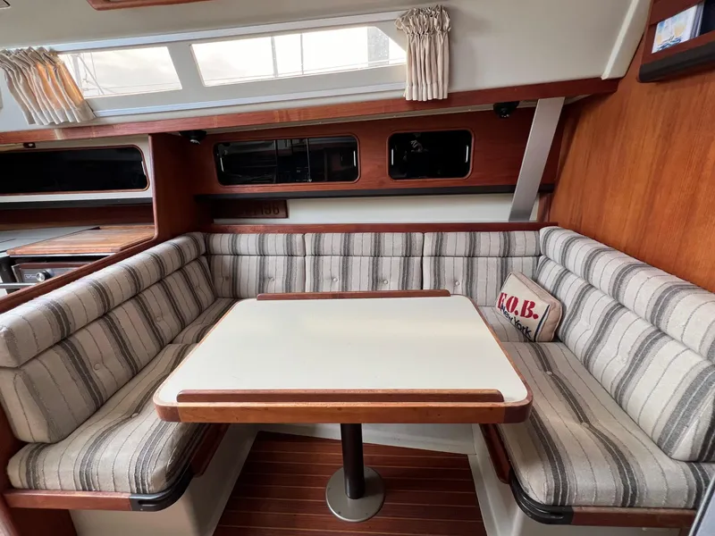 Slide: The Image of Interior of 1983 C&C 35 MKIII sailboat with striped seating and wooden table. - 38