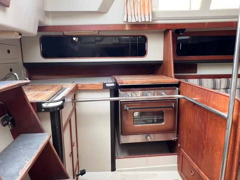 Slide: The Image of 1983 C&C 35 MKIII yacht interior with wood cabinetry and compact kitchen area. - 39