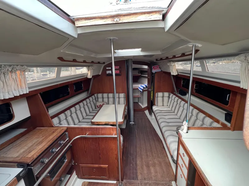 Slide: The Image of Interior of a 1983 C&C 35 MKIII sailboat with wood finishes and striped seating. - 4