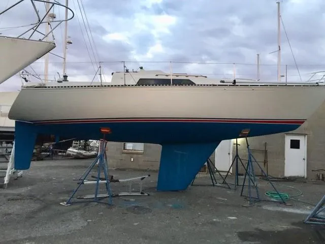 Slide: The Image of 1983 C&C 35 MKIII sailboat on stands, blue hull, in a boatyard. - 45