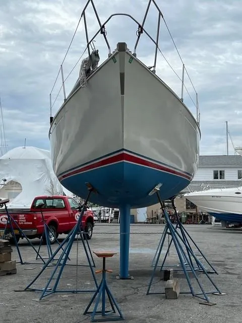 Slide: The Image of 1983 C&C 35 MKIII sailboat on stands in a boatyard, overcast sky. - 46