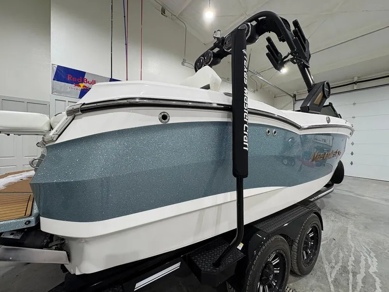 Slide: The Image of 2022 MasterCraft XStar S boat in a garage, featuring a sleek design and dual-axle trailer. - 4