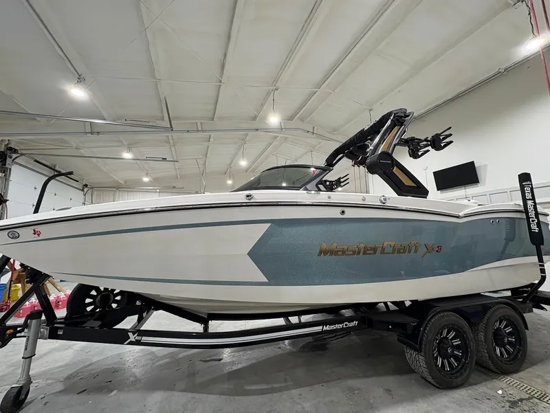Slide: The Image of 2022 MasterCraft XStar S boat on trailer in indoor storage facility. - 5