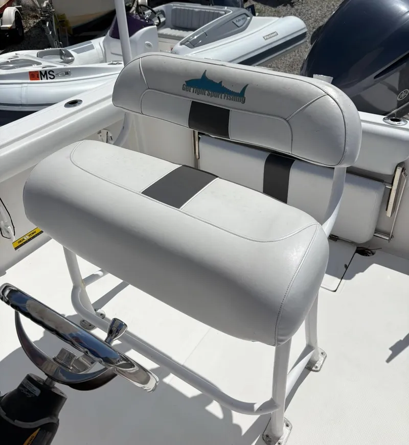 Slide: The Image of 2013 Tidewater 230 boat seat with white and black upholstery. - 10