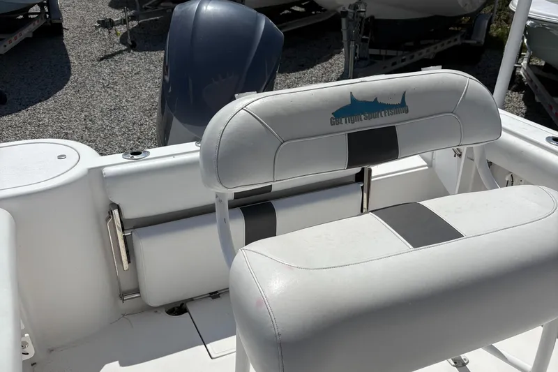 Slide: The Image of 2013 Tidewater 230 boat interior with cushioned seating and motor in background. - 9