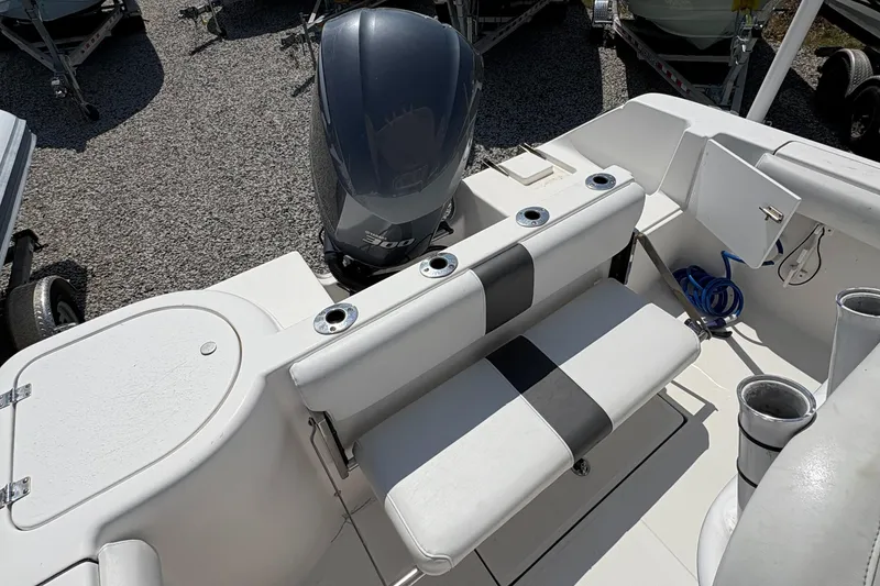 Slide: The Image of 2013 Tidewater 230 boat interior with seating and motor, featuring cup holders and storage. - 11