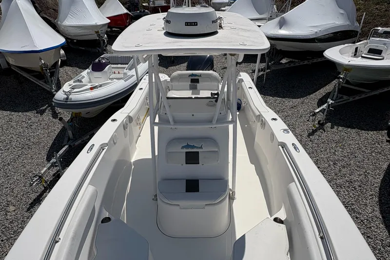 Slide: The Image of 2013 Tidewater 230 boat, white interior, parked among other covered boats. - 18