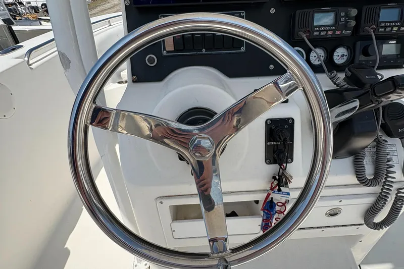 Slide: The Image of Steering wheel of a 2013 Tidewater 230 boat, featuring control panel and gauges. - 22