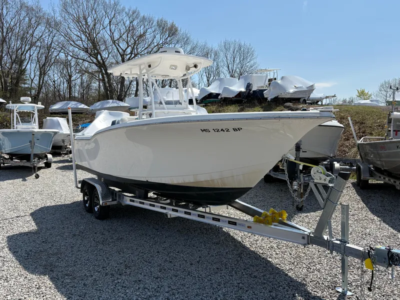 Slide: The Image of 2013 Tidewater 230 boat on trailer, parked on gravel lot with other boats. - 3
