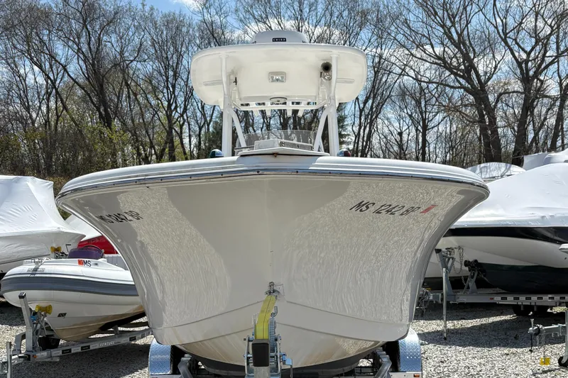 Slide: The Image of 2013 Tidewater 230 boat on trailer, surrounded by trees and other boats. - 6